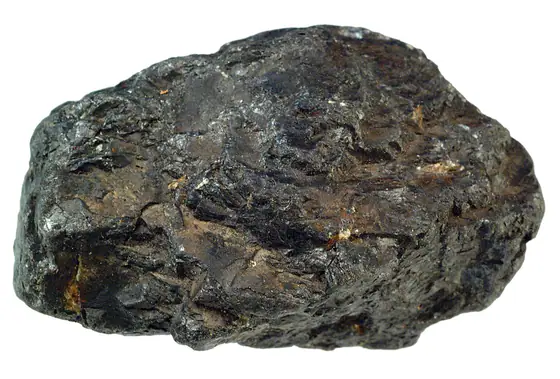 Black submetallic massive ilmenite hand specimen with uneven weathered surfaces