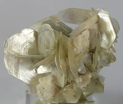 Muscovite mineral specimen with silvery sheet-like mica crystals on albite