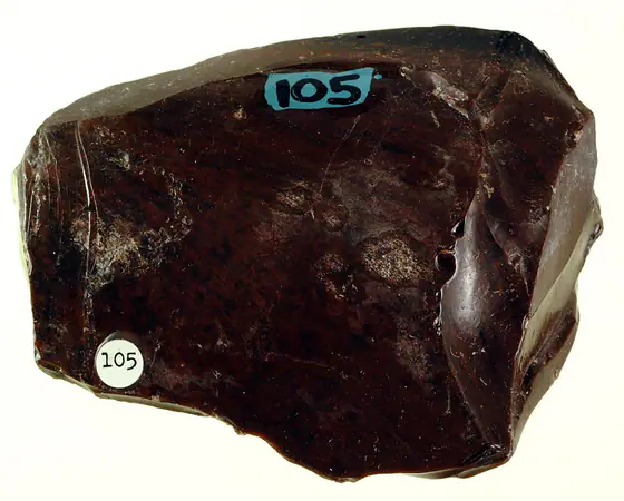 Black obsidian hand specimen showing a glassy surface and curved fracture